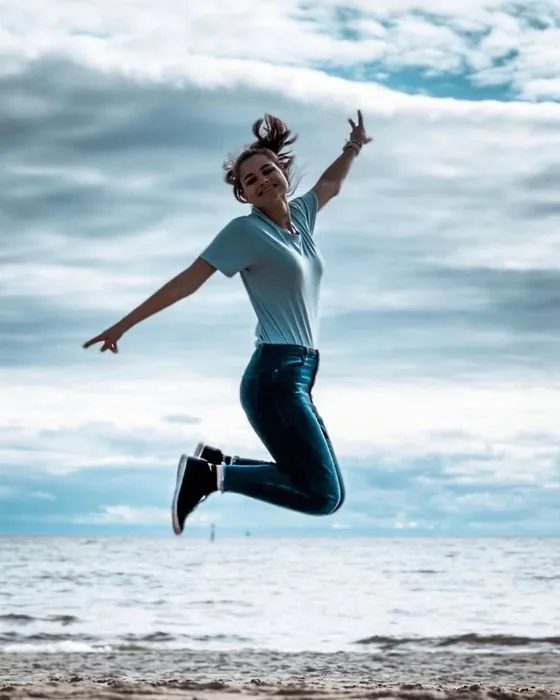 Sophie qui saute de joie sur une plage en Australie