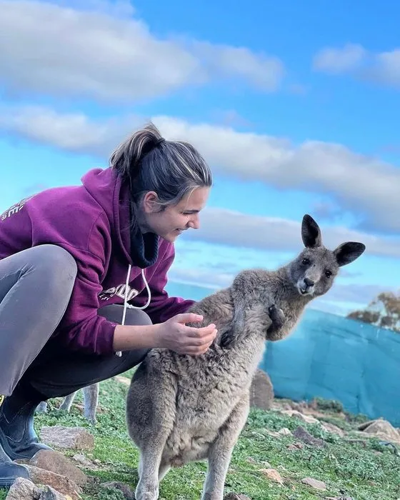 Sophie accroupie à côté d'un kangourou